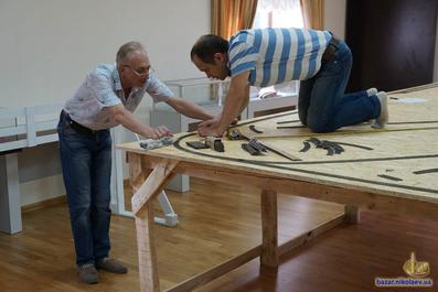 Анатолий Смышляев и Леонид Фисенко во время монтажа рельс на макет